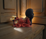 Estatua de Buda tumbado en posición de meditación con túnica roja, ideal para espacios de calma