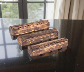 Cajas de incienso de madera decoradas con símbolos dorados en ambiente armonioso