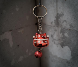 Llavero Maneki-neko rojo decorado con símbolo de la suerte