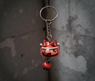 Llavero Maneki-neko rojo decorado con símbolo de la suerte