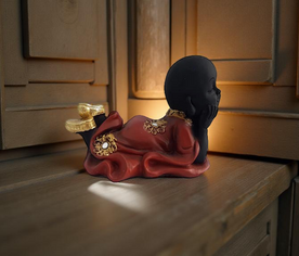 Estatua de Buda tumbado en posición de meditación con túnica roja, ideal para espacios de calma
